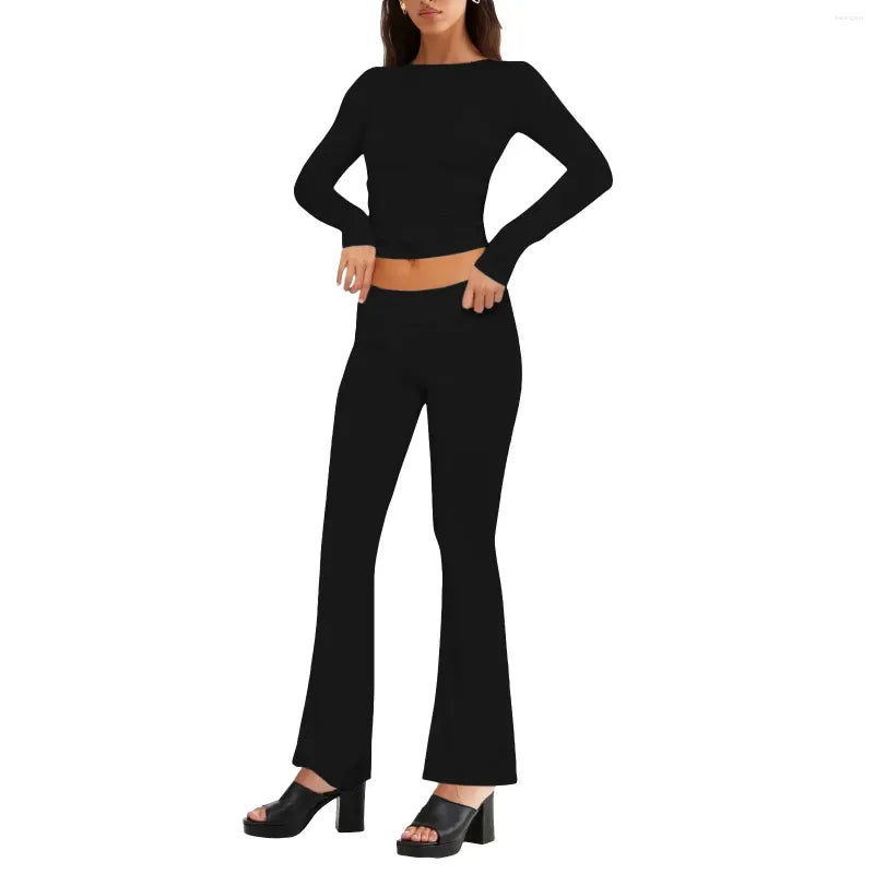 Woman in black long-sleeve top and flared pants, wearing black platform heels. Fashionable outfit, modern style, women's clothing.