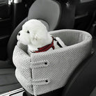 Small white dog in a cozy gray pet car seat, wearing a red harness. Ideal for safe pet travel, comfortable dog car seat, pet accessories.