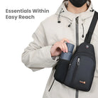 Person wearing a beige jacket using a black water bottle carrier chest bag with multiple pockets, ideal for travel and outdoor activities.