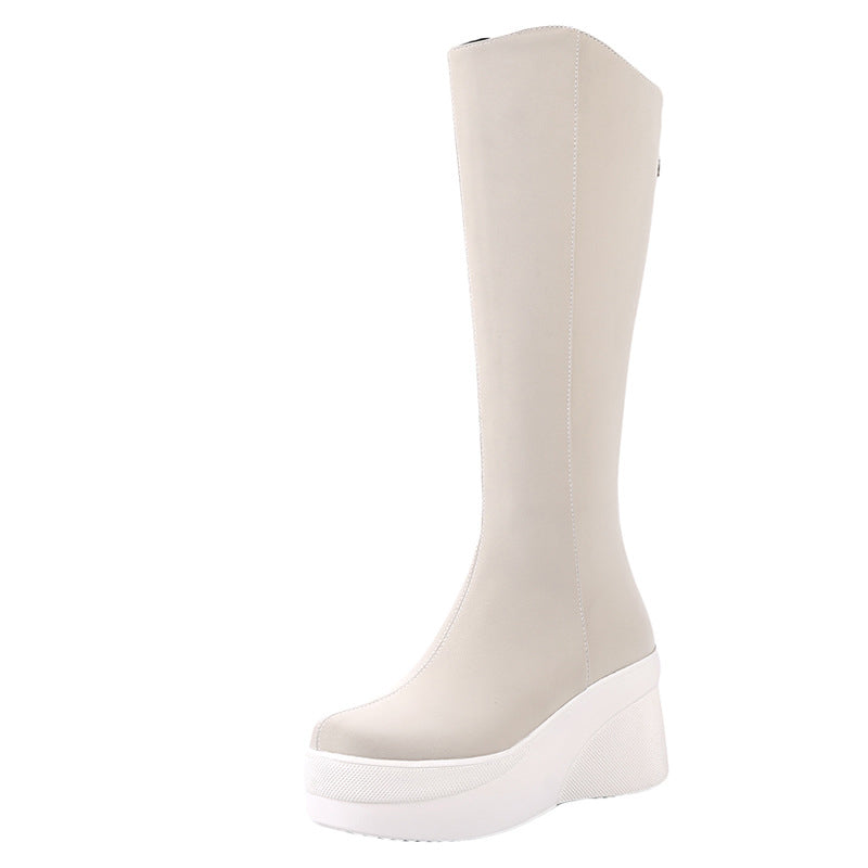 Beige knee-high platform boot with white sole, featuring sleek design and modern style. Perfect for fashion-forward footwear enthusiasts.