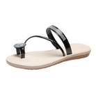 Black and beige women's sandal with rhinestone strap and floral embellishment, featuring a comfortable flat sole. Perfect for casual summer wear.