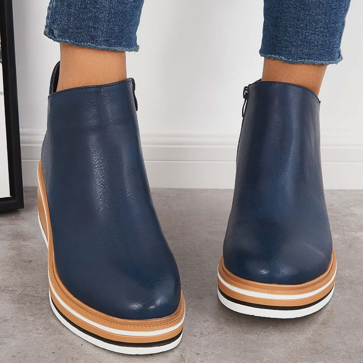 Navy blue leather ankle boots with platform sole, worn with denim jeans. Stylish women's footwear, casual fashion, comfortable shoes.