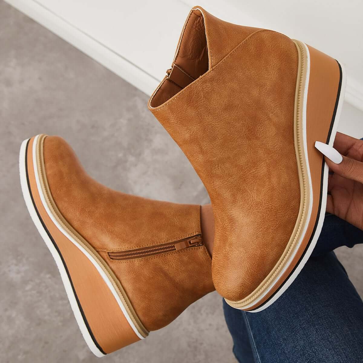 Tan wedge ankle boots with side zipper, white platform sole, and textured faux leather finish. Stylish women's footwear for casual and trendy outfits.