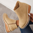 Beige wedge ankle boots with side zipper, white and brown platform sole, worn with jeans. Stylish women's footwear, casual fashion.