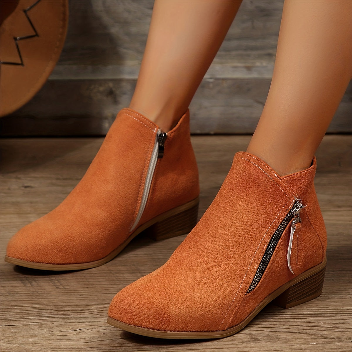 Women's suede ankle boots with side zippers, featuring a low block heel and stylish orange-brown color, perfect for casual fall fashion.