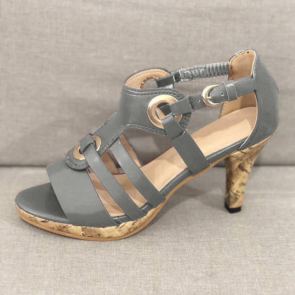 Gray strappy high heel sandal with cork sole, featuring circular buckle accents. Stylish women's footwear, perfect for summer fashion and casual wear.