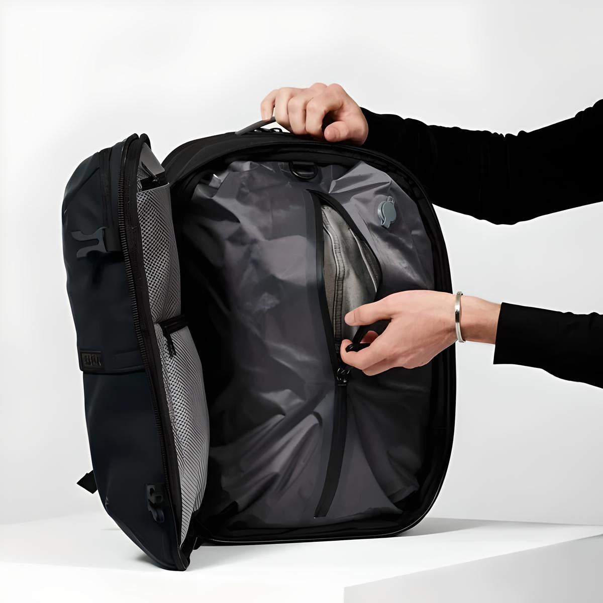 Person opening a sleek black travel backpack with organized compartments, showcasing efficient packing design. Ideal for modern travelers and commuters.