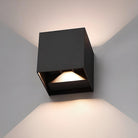 Modern black cube wall sconce with LED light, minimalist design, illuminating a room with soft, ambient lighting. Ideal for contemporary home decor.