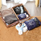 Open suitcase on a carpeted floor with neatly packed clothes in branded drawstring bags, showcasing efficient travel packing and organization.