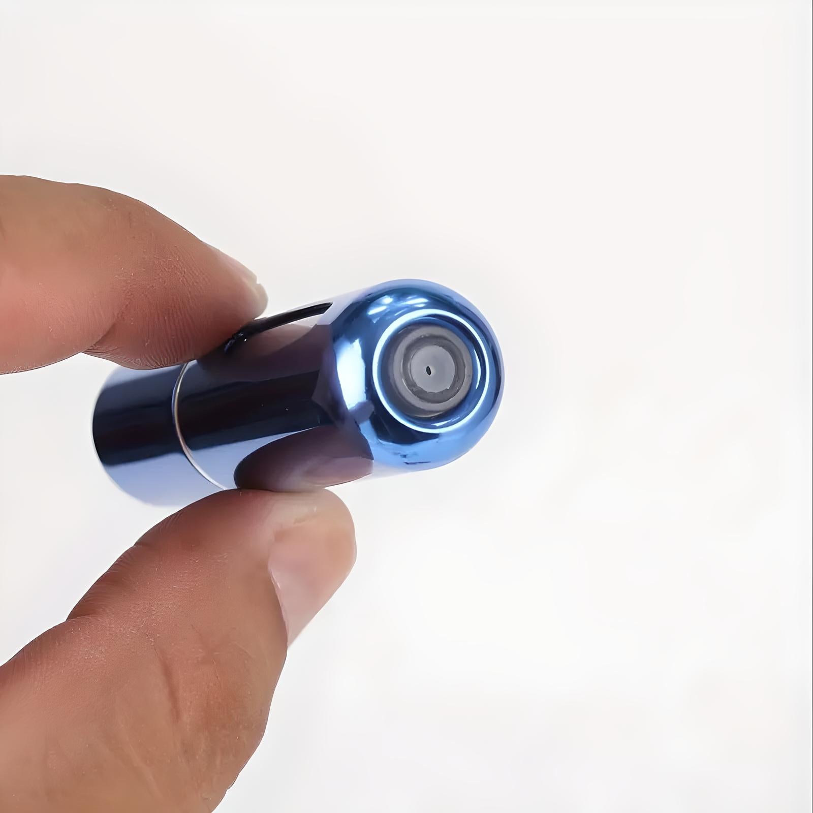 Close-up of a blue mini camera lens held between fingers, showcasing compact design and sleek metallic finish. Ideal for portable surveillance and security.