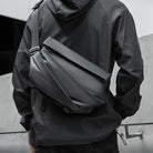 Man wearing sleek black crossbody bag and jacket, showcasing modern urban fashion. Stylish accessory for travel, commuting, and everyday use.