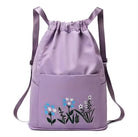 Purple drawstring backpack with floral embroidery, featuring adjustable straps and front pocket. Stylish, trendy bag for women, perfect for casual outings.