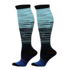 Knee-high compression socks with gradient blue and black stripes, designed for improved circulation and comfort. Ideal for travel and sports enthusiasts.