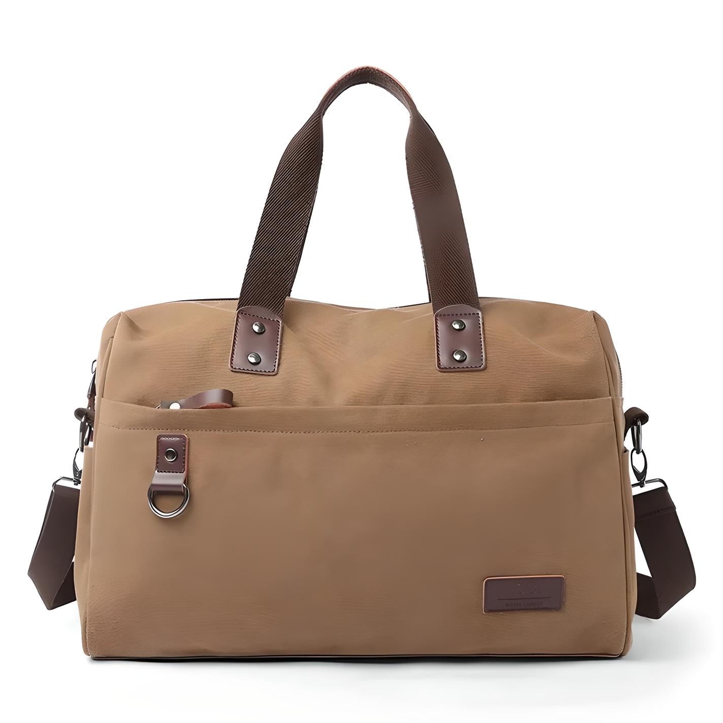 Tan canvas duffel bag with brown leather handles and adjustable shoulder strap, featuring front pocket and metal ring. Ideal for travel and gym use.