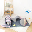 Cat playing in a shark-shaped tunnel toy on a soft rug, featuring a starfish design. Perfect pet accessory for indoor feline entertainment.