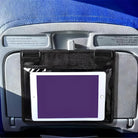 Airplane seat back with tablet holder displaying a blank screen, attached to tray table. Ideal for in-flight entertainment and travel convenience.