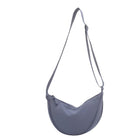 Light blue crossbody bag with adjustable strap, minimalist design, and crescent shape. Perfect for casual outings and everyday use. Fashion accessory.