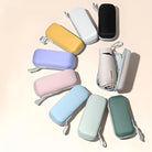 Colorful travel pouches arranged in a circle, featuring pastel shades and a rolled-up umbrella inside one. Ideal for organizing accessories.