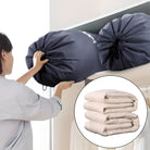 Person storing bedding in a large, black, drawstring storage bag on a shelf; inset shows folded beige comforters. Ideal for home organization.