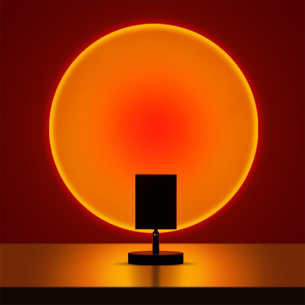 Modern sunset projection lamp casting warm orange glow on wall, creating ambient lighting. Perfect for home decor, mood lighting, and relaxation.