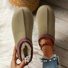 Cozy women's winter slippers with faux fur lining, embroidered trim, and pearl-accented denim jeans. Perfect for warm, stylish indoor wear.