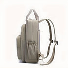 Sleek beige backpack with multiple compartments, ergonomic straps, and side pockets. Ideal for travel, school, or work. Durable and stylish design.