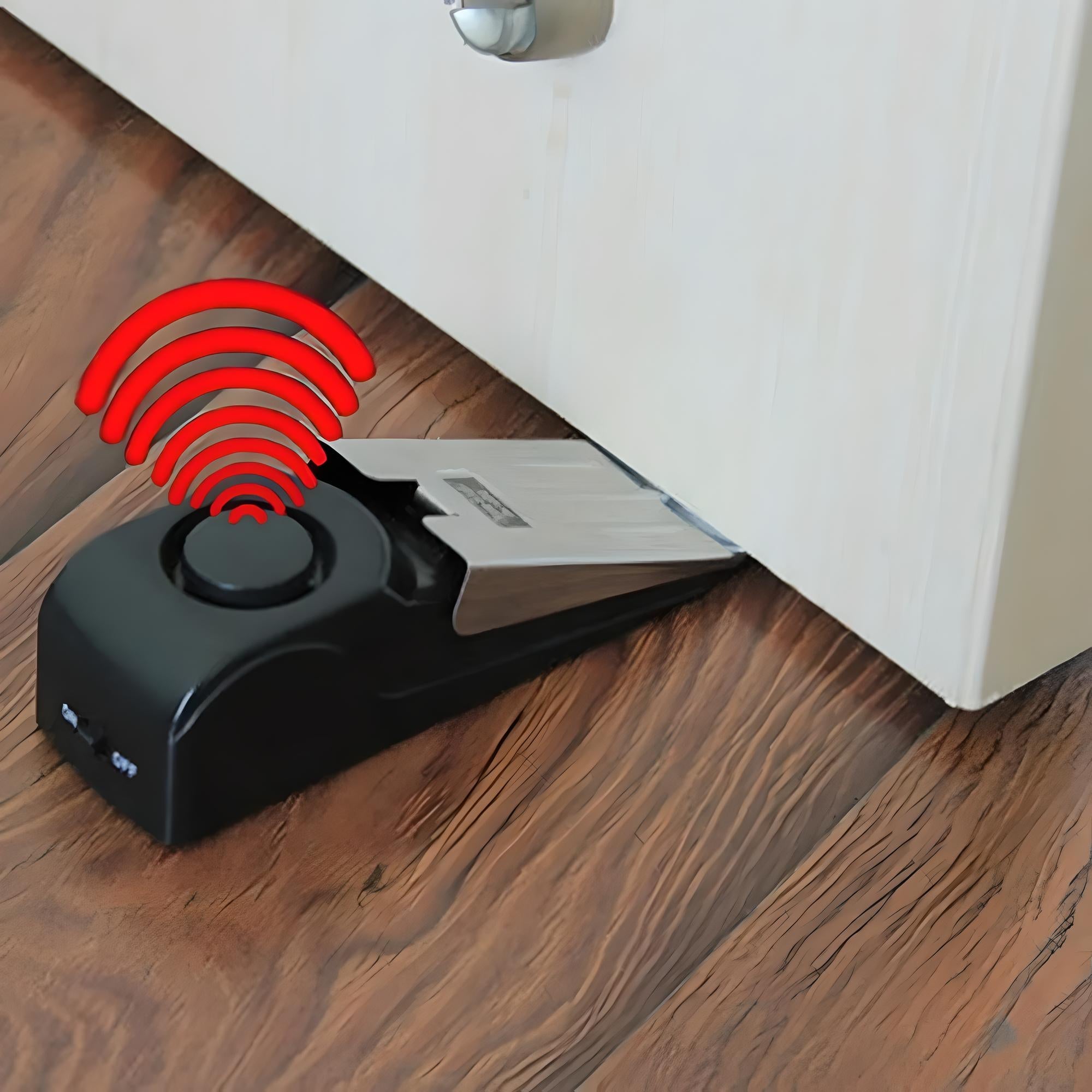 Door stop alarm on wooden floor, emitting red sound waves. Security device, anti-theft, home protection, portable wedge design, battery-operated.