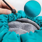 Close-up of a turquoise waterproof car cover with elastic drawstring, showcasing durable fabric texture. Ideal for vehicle protection and outdoor use.