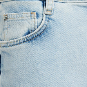 Close-up of light blue denim jeans pocket, showcasing classic stitching and rivet detail. Perfect for casual fashion and style enthusiasts.