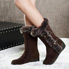 Women's brown suede winter boots with faux fur trim and buckle accents, featuring a flat sole. Stylish and cozy footwear for cold weather.