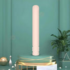 Sleek beige cylindrical air purifier on a modern green background with decorative plants and geometric accents, enhancing home air quality.