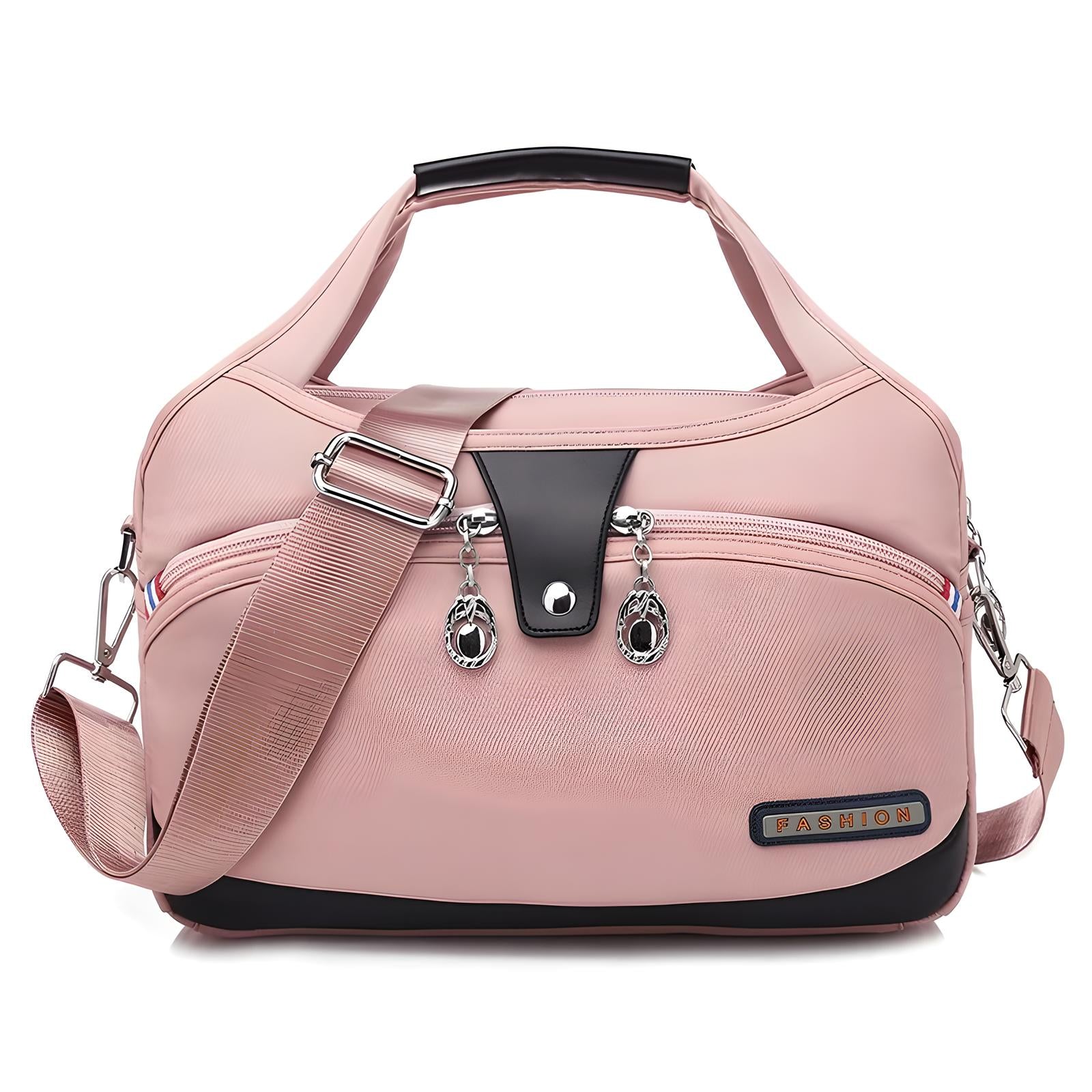 Pink women's fashion handbag with adjustable shoulder strap, front zipper pocket, and decorative metal accents. Stylish, versatile, and trendy accessory.