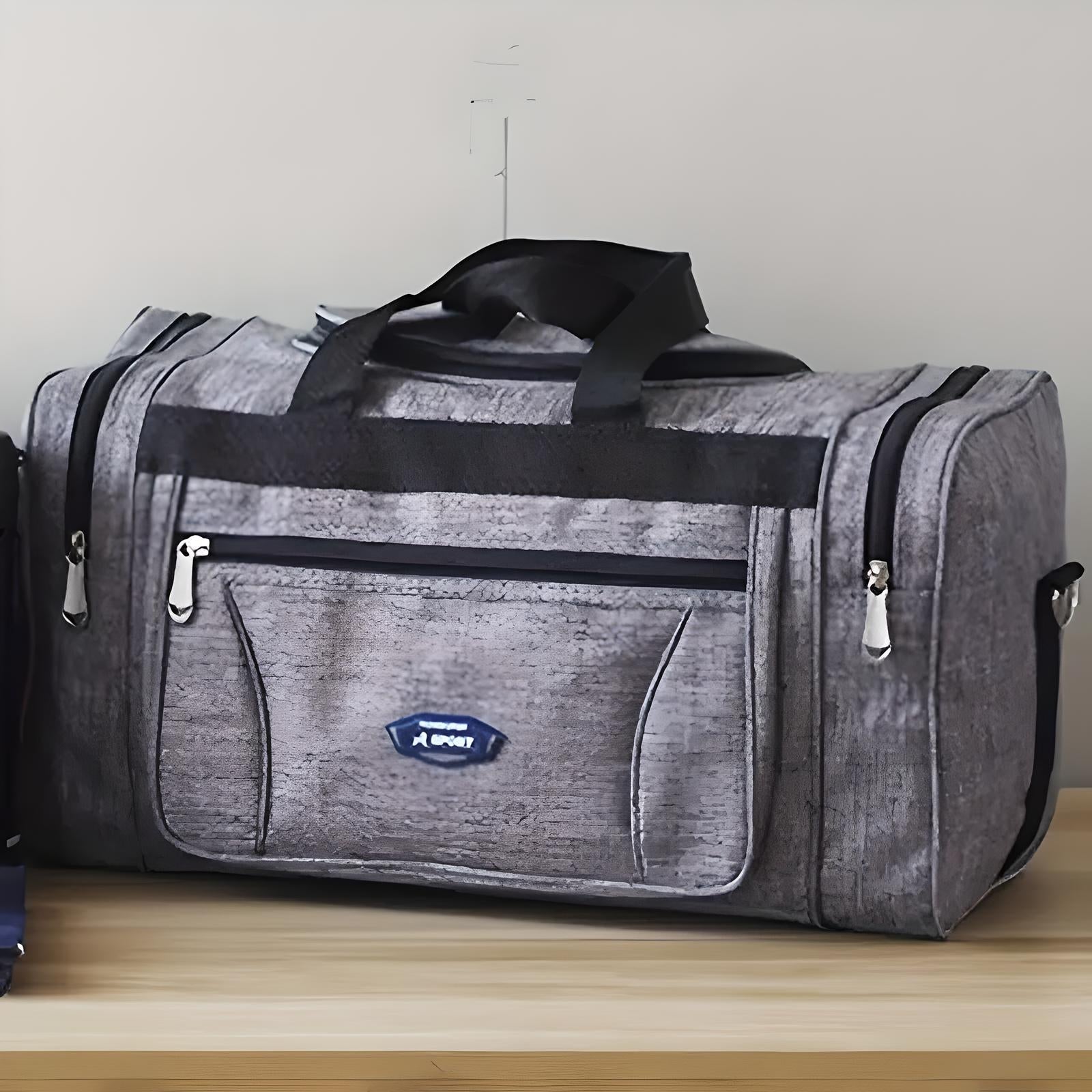 Gray sports duffel bag with black handles and multiple zippered compartments on a wooden surface. Ideal for gym, travel, and outdoor activities.