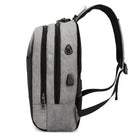 Sleek gray anti-theft backpack with USB charging port, dual zippers, and ergonomic straps. Ideal for travel, school, and tech-savvy commuters.