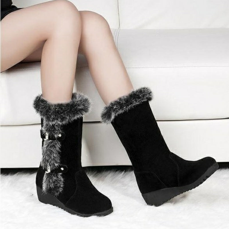 Black suede winter boots with faux fur trim and wedge heel, featuring decorative buckles, perfect for stylish cold-weather fashion.