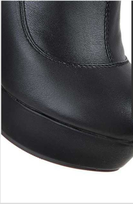 Close-up of a black leather platform boot with a high heel, showcasing detailed stitching and sleek design. Fashion footwear, women's boots.