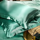 Luxurious green silk pillowcases on a bed, showcasing smooth texture and elegant sheen. Perfect for enhancing bedroom decor and promoting restful sleep.