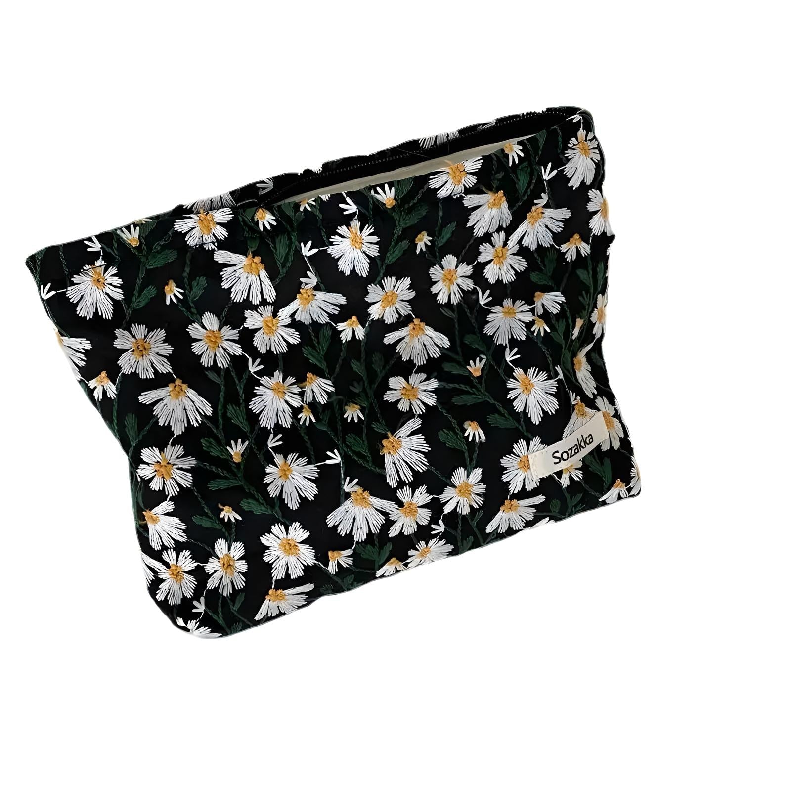 Floral cosmetic bag with white daisy pattern on black background, featuring a zipper closure. Perfect for travel or everyday use. Stylish and practical.