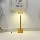 Modern gold table lamp with sleek design, illuminating a minimalist room. Perfect for contemporary home decor and ambient lighting solutions.