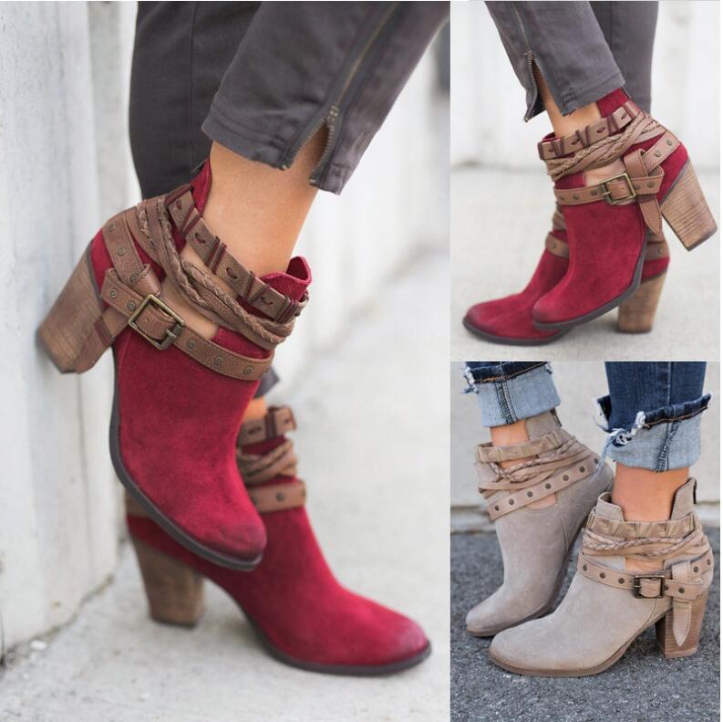 Women's suede ankle boots with chunky wooden heels, featuring decorative straps and buckles. Available in red and beige. Fashionable fall footwear.