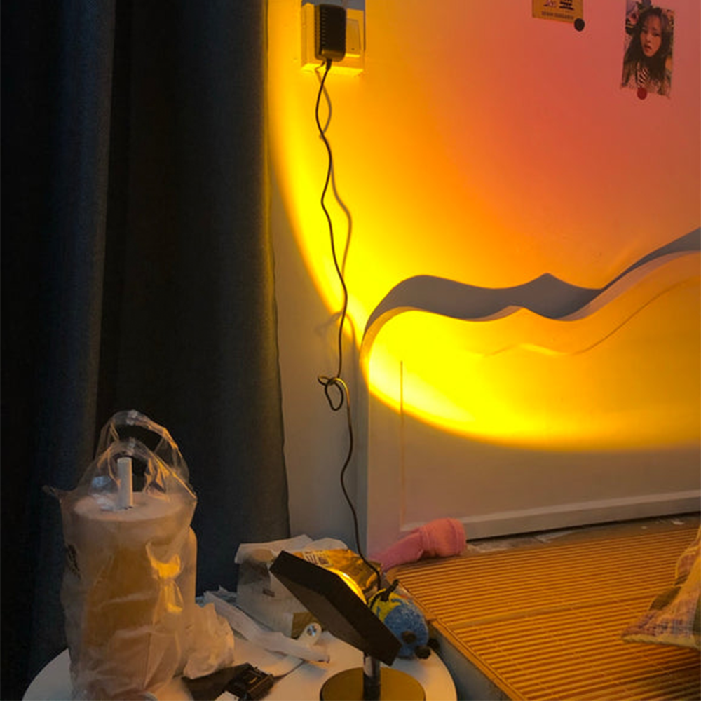 Cozy bedroom corner with warm yellow LED wall lights, a small table with a tissue box, and a smartphone on a stand, creating a relaxing ambiance.