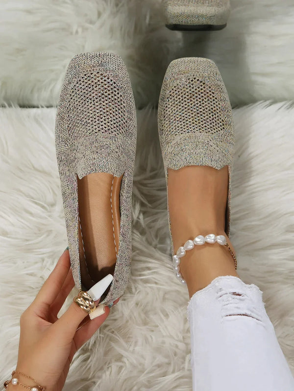 Women's beige knit loafers on white fur rug, featuring square toe design. Stylish, comfortable footwear ideal for casual wear. Fashionable shoes.