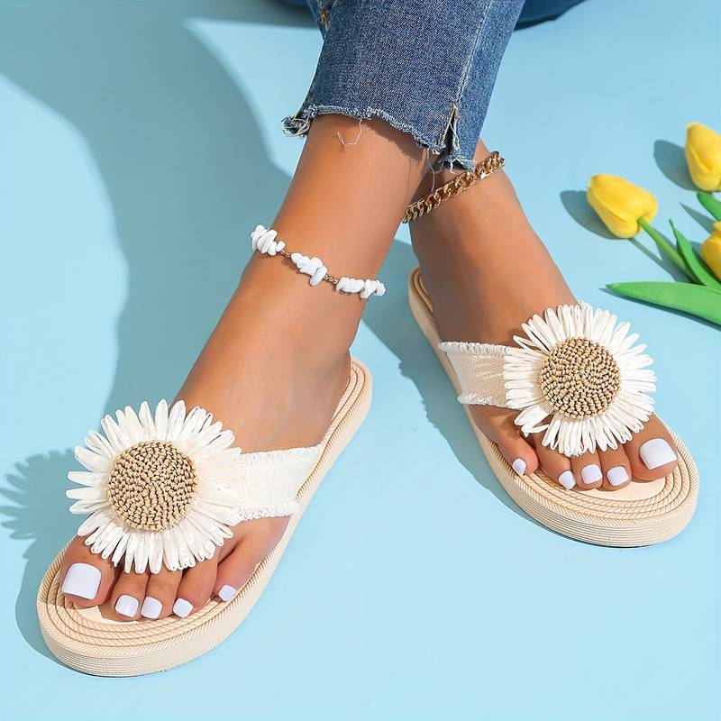 Women's sandals with white daisy flower design, worn with blue jeans and anklets, featuring a summer fashion style. Perfect for casual beachwear.