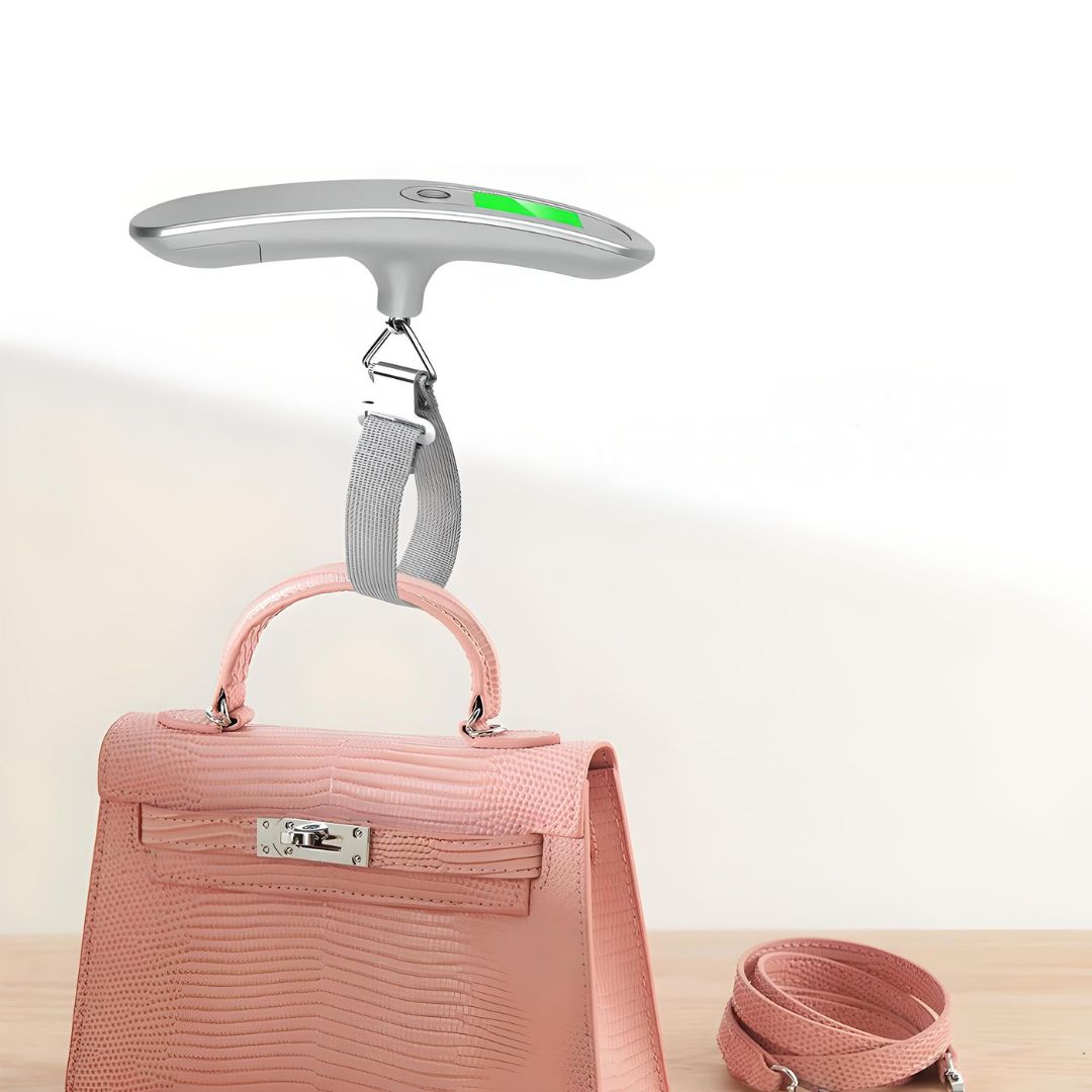 Digital luggage scale weighing a pink crocodile leather handbag on a wooden surface, featuring a green LCD display. Travel accessory, precise measurement.