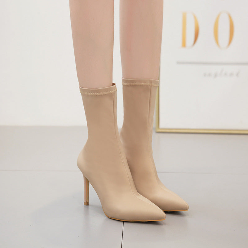 Beige high-heeled ankle boots with pointed toes, sleek design, and smooth finish, perfect for fashion-forward outfits and elegant styling.