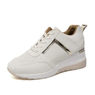 White women's sneaker with perforated design, metallic accents, and cushioned sole. Stylish, comfortable footwear for casual wear.