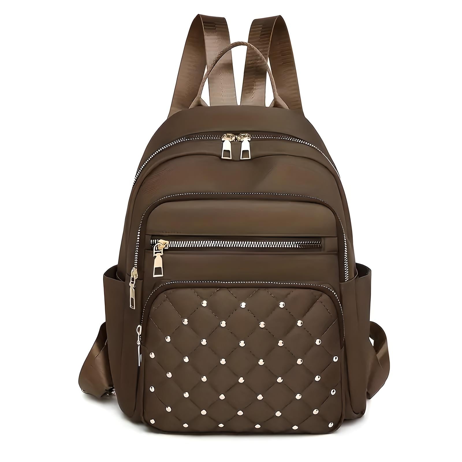 Brown leather backpack with quilted front pocket, silver studs, and multiple zippered compartments. Stylish, durable, and perfect for travel or daily use.