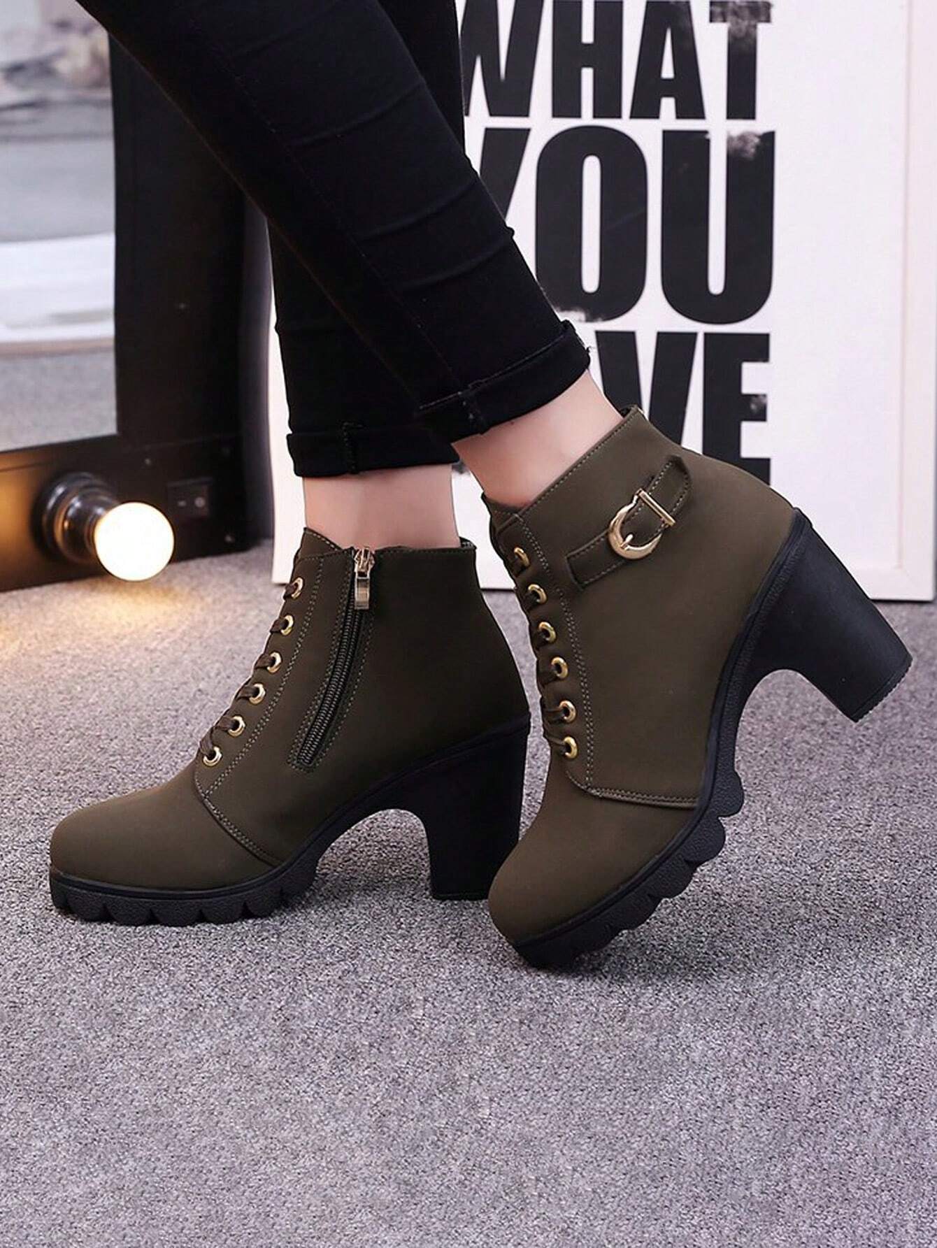 Olive green ankle boots with chunky heels, side zipper, and buckle detail, worn with black jeans. Stylish women's footwear for fall fashion.