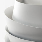 Minimalist white ceramic bowls stacked, showcasing smooth texture and modern design. Perfect for kitchen decor, dining, and home organization.