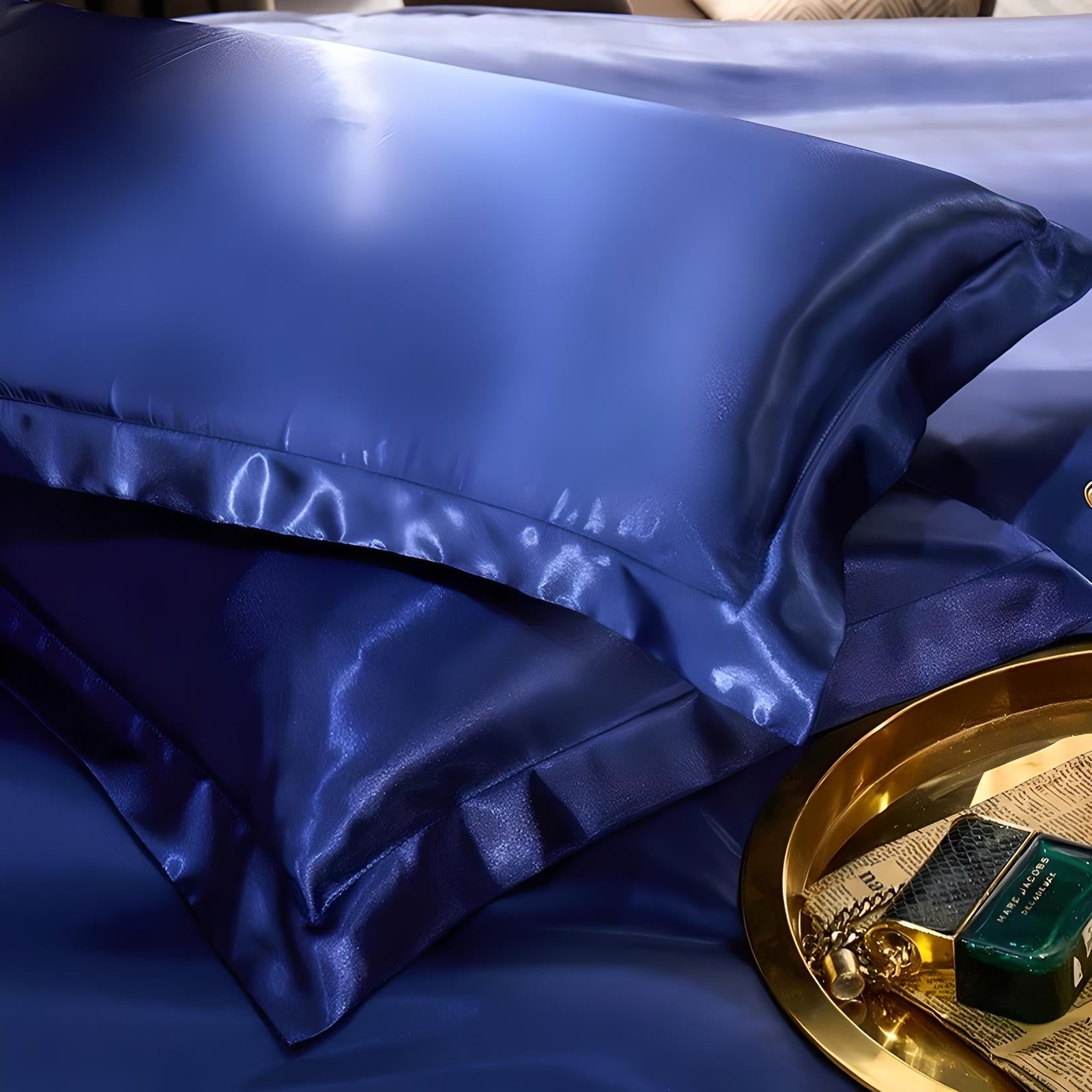 Luxurious navy blue satin pillowcases on a bed, showcasing smooth, glossy texture. Perfect for elegant bedroom decor and enhancing sleep comfort.